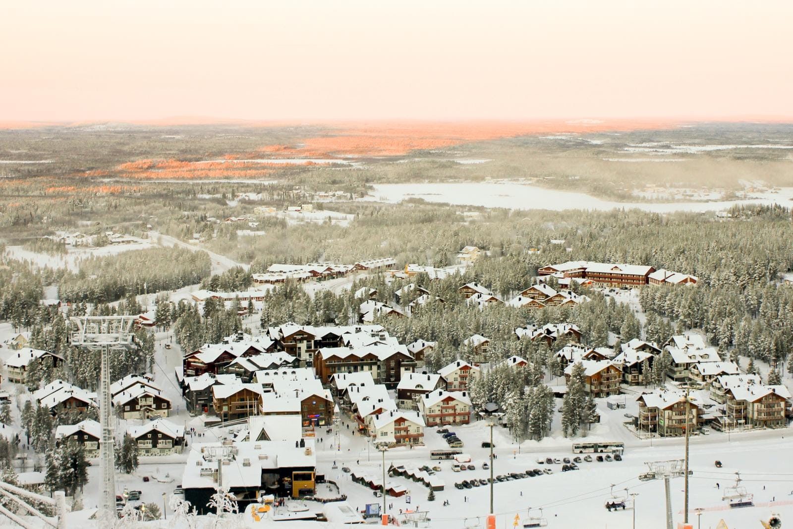 Verschneites Skigebiet in Finnland, Sonnenuntergang beleuchtet die Winterlandschaft.