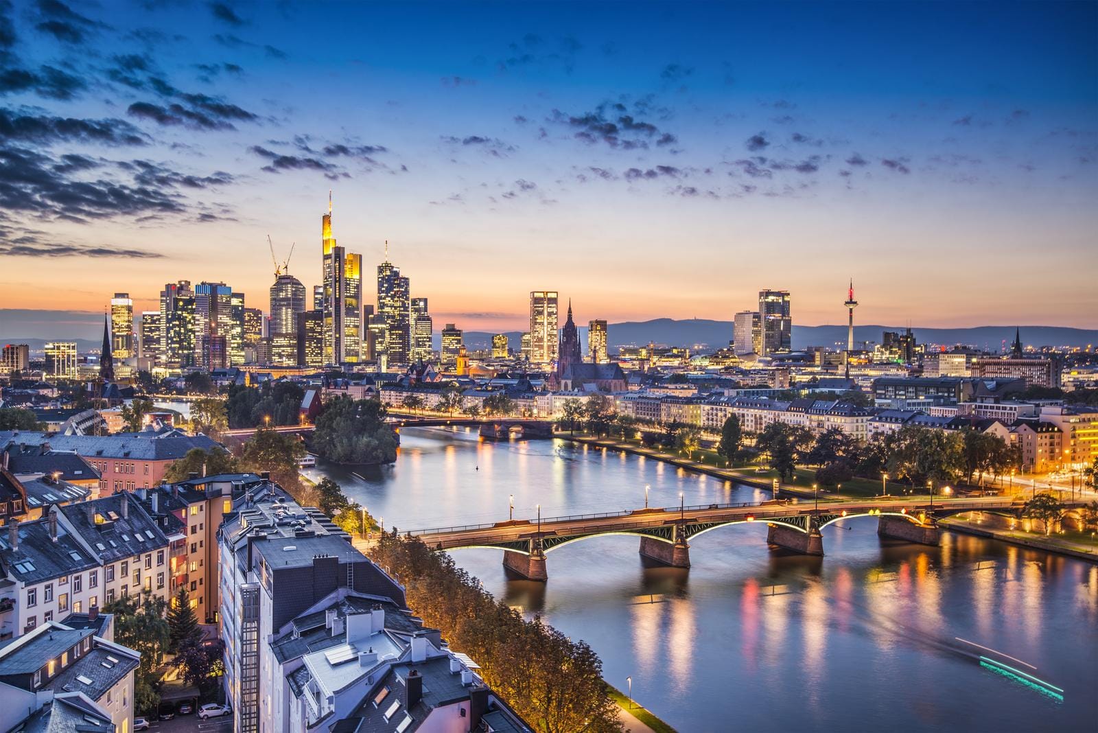 Frankfurt bei Sonnenuntergang, Skyline mit Wolkenkratzern und Main-Brücke.