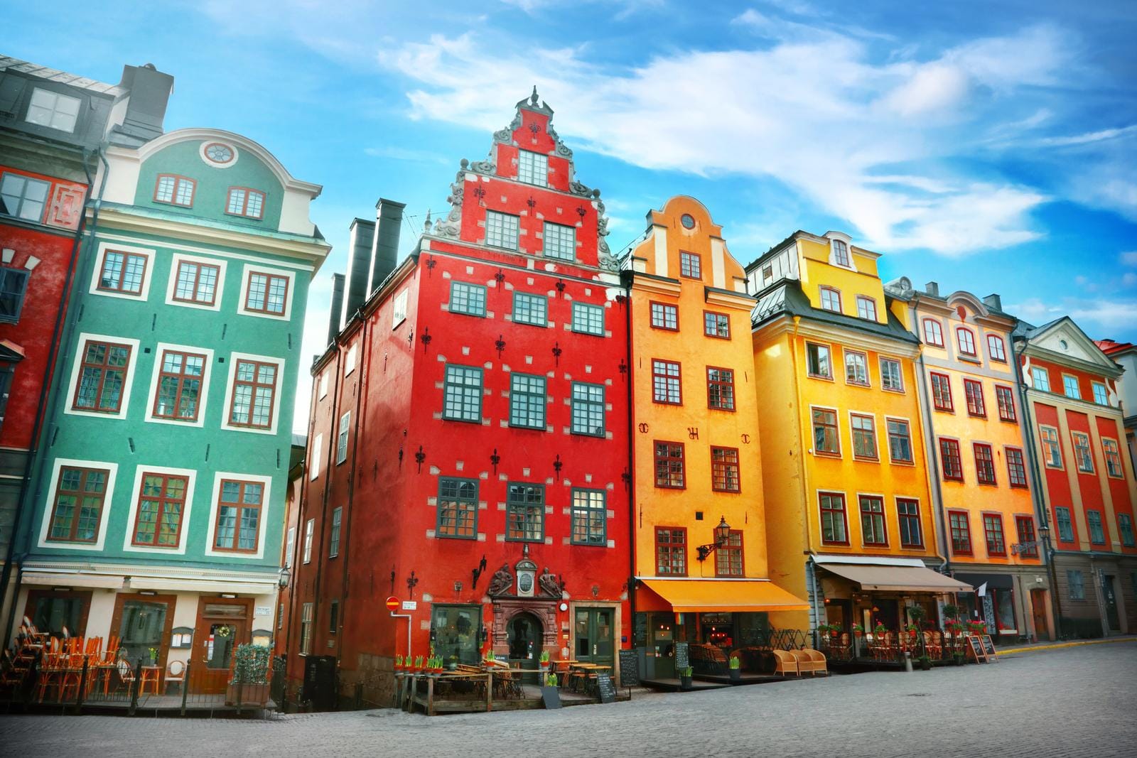Bunte historische Fassaden in Stockholm, Schweden, mit blauem Himmel im Hintergrund.