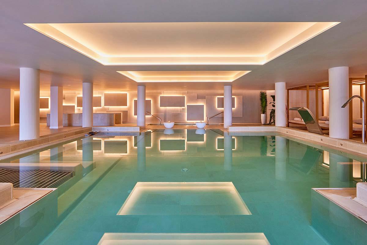 Moderner, eleganter Hotel-Spa-Pool mit stimmungsvoller Beleuchtung und Liegeflächen.