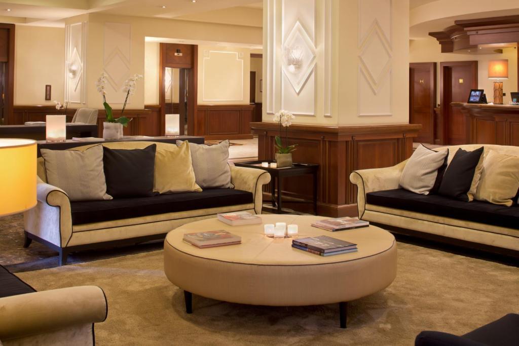 Elegante Hotel-Lobby mit beigen Sofas, Holzakzenten und warmem Licht.