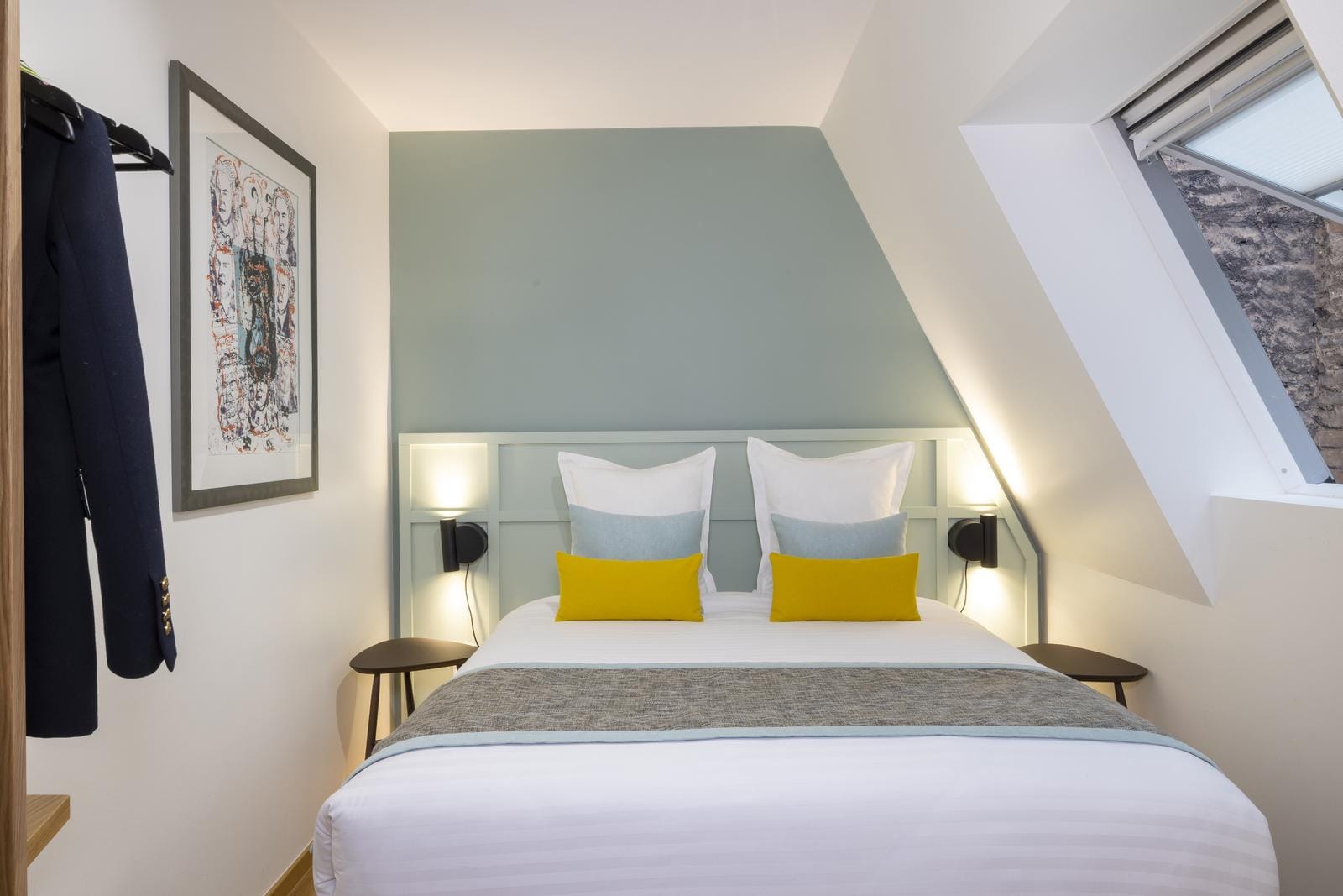 Kompaktes, modernes Hotelzimmer mit stilvollem Doppelbett und dekorativen Kissen.