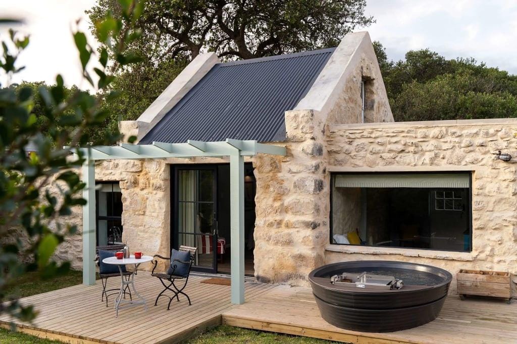 Rustikales Steinhaus mit Terrasse, Whirlpool und gemĂĽtlicher Sitzgelegenheit im Freien.