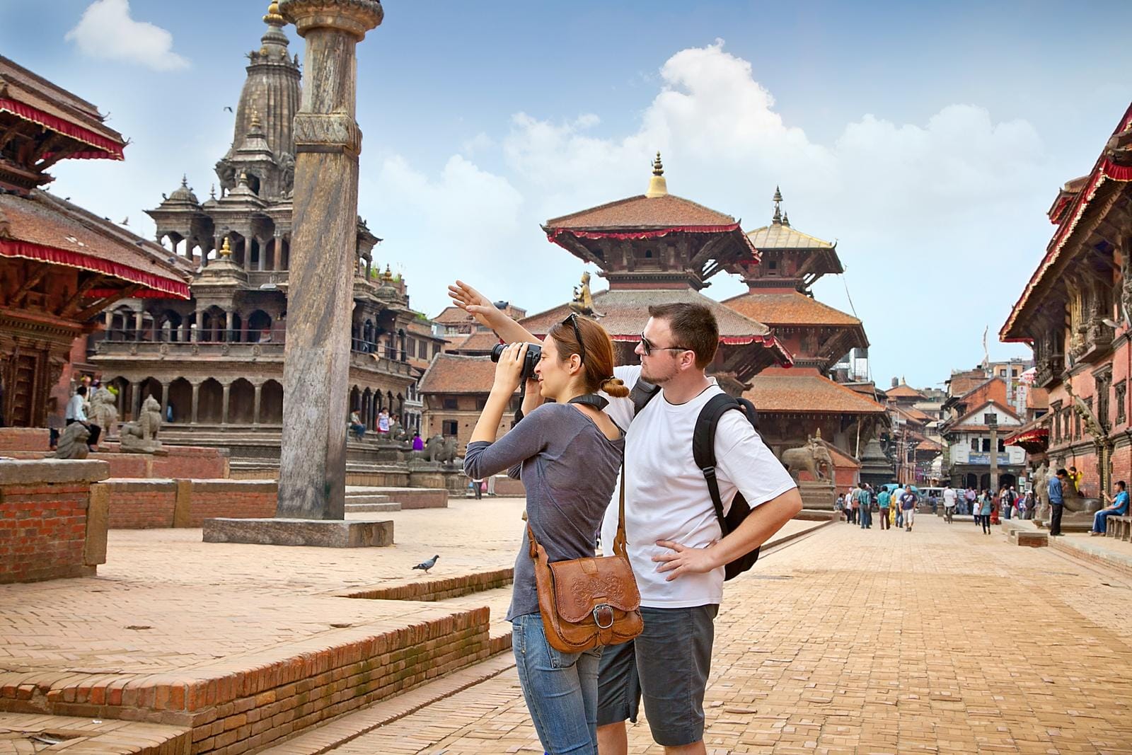 Touristen in Patans Durbar-Platz, Nepal, bewundern historische Tempel und Architektur.