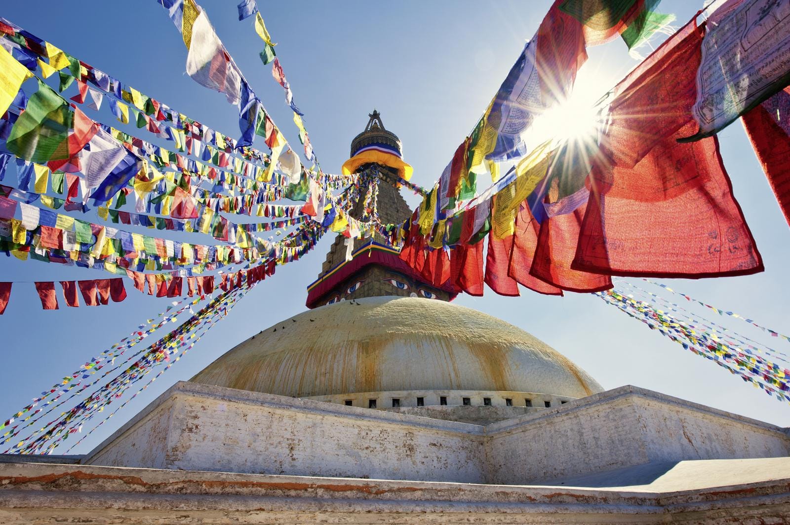 In Kathmandu ragt die Boudhanath-Stupa empor, umgeben von bunten Gebetsfahnen und spiritueller Atmosphäre