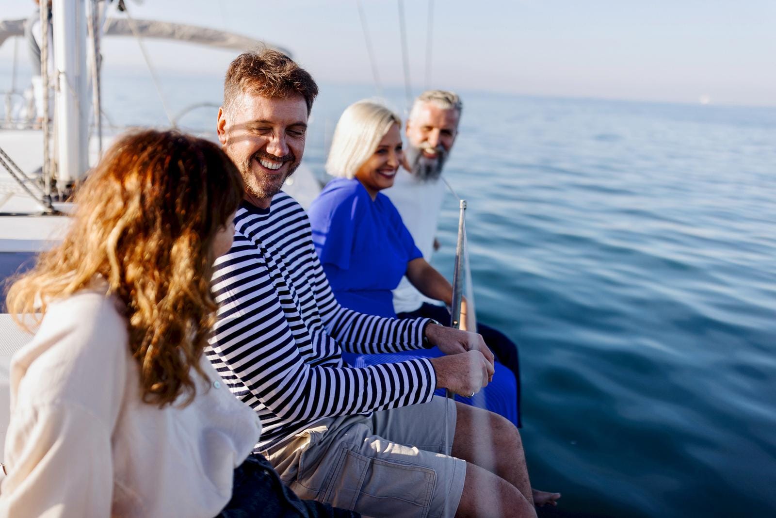 Vier Leute auf einem Boot genießen den sonnigen Tag auf dem Meer.