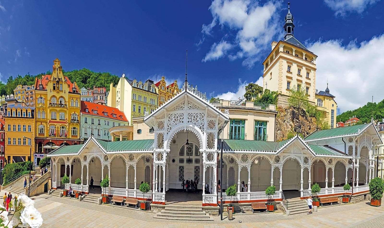 Historische Kolonnade in Karlsbad, Tschechien, mit bunten Gebäuden und blauem Himmel.