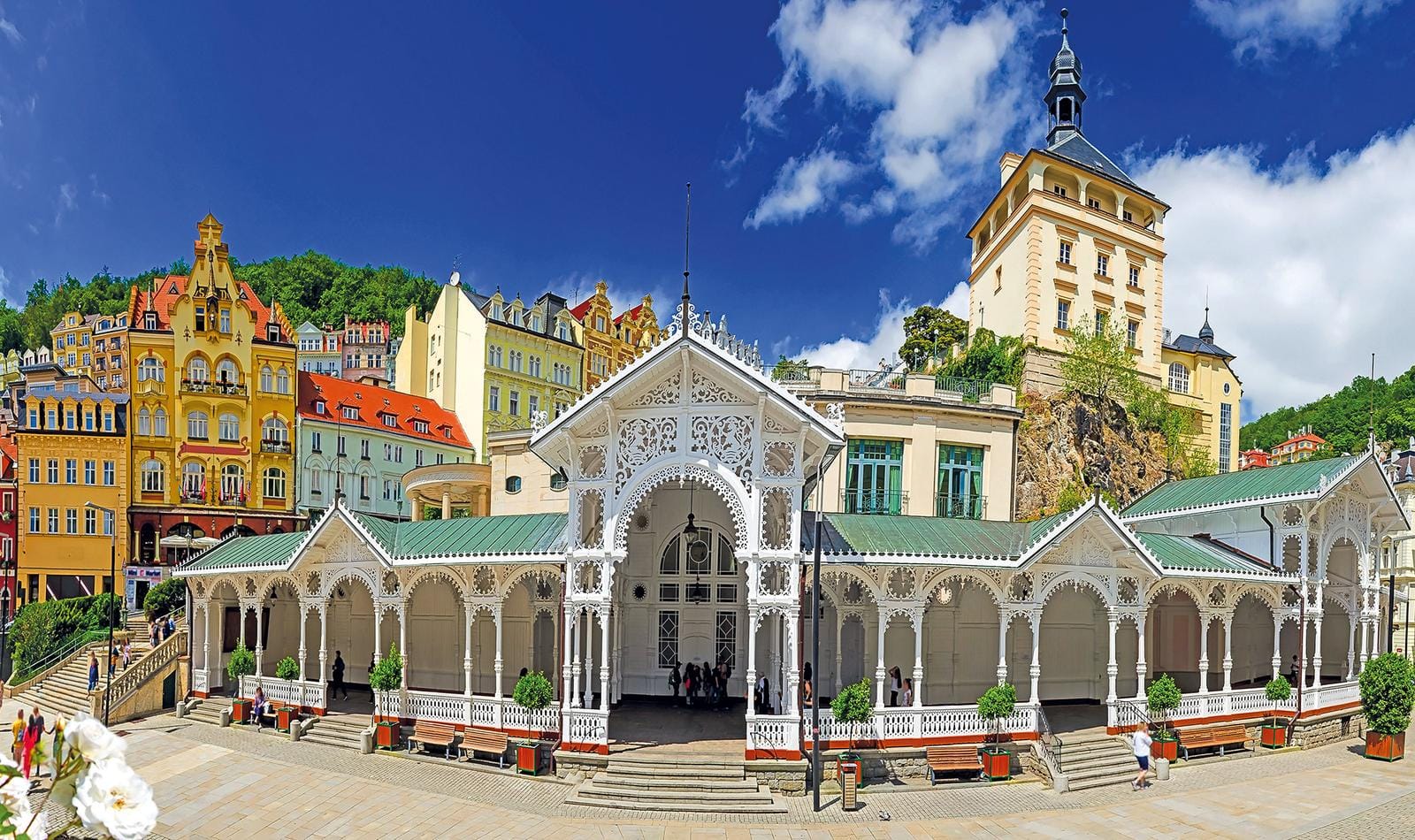 Historische Kolonnade in Karlsbad, Tschechien, mit bunten Gebäuden und blauem Himmel.
