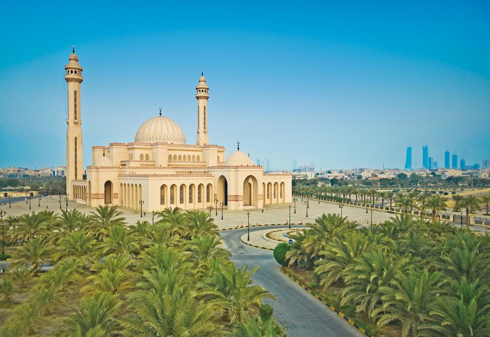 Eine beeindruckende Moschee mit Palmen im Vordergrund, gelegen in Manama, Bahrain.