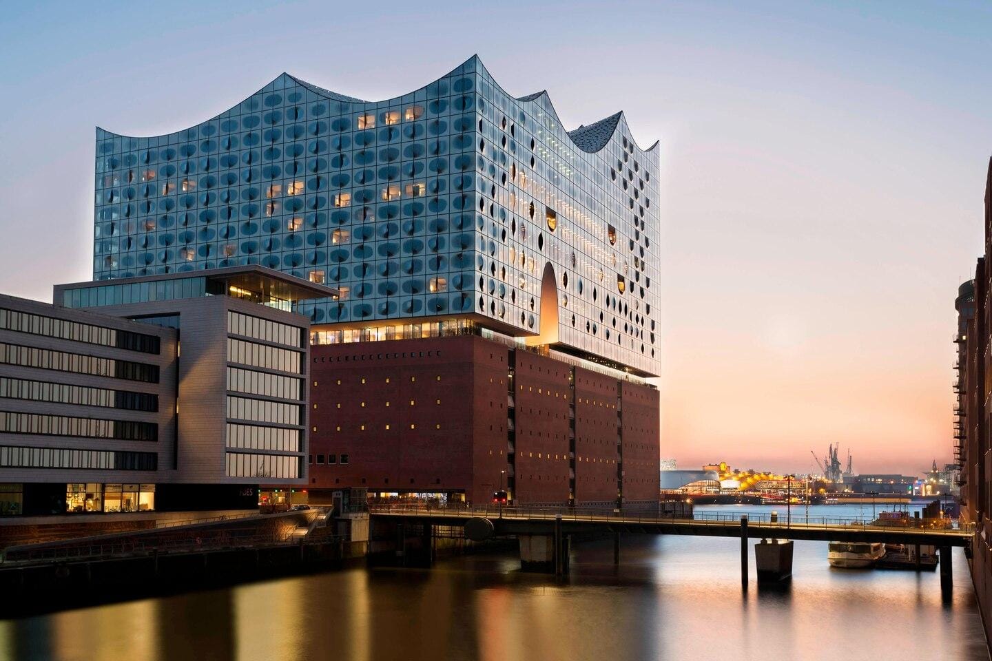 Hamburg, Elbphilharmonie bei Sonnenuntergang, moderne Glasarchitektur am Wasser.