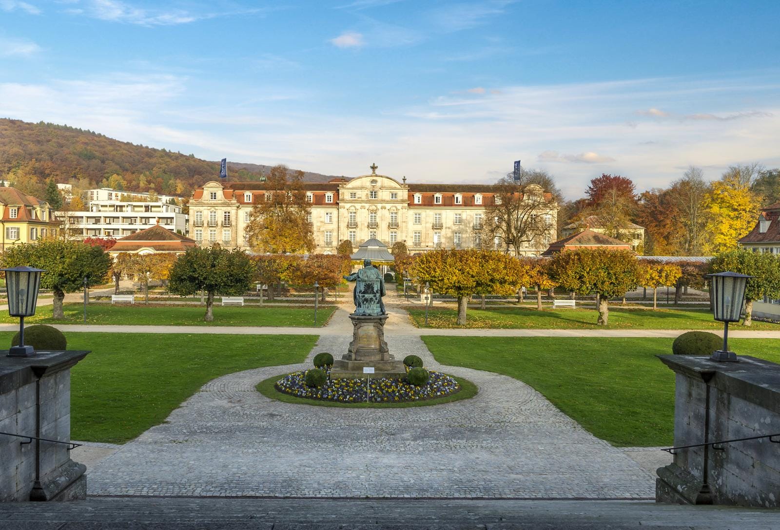 Historisches Gebäude in Baden-Baden, umgeben von Herbstbäumen und gepflegten Gärten.