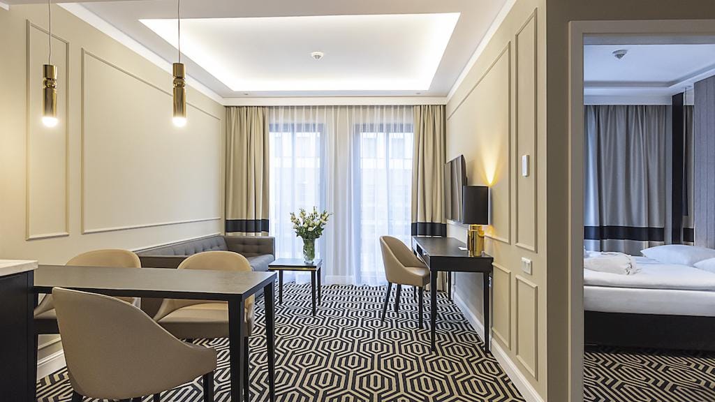 Elegantes Hotelzimmer in neutralen Tönen, mit modernem Dekor und gemütlicher Sitzecke.