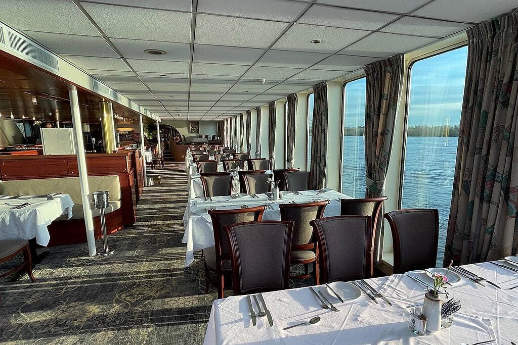 Gemütliches Flusskreuzfahrtschiff-Restaurant, segelnd durch die malerische Landschaft Europas.