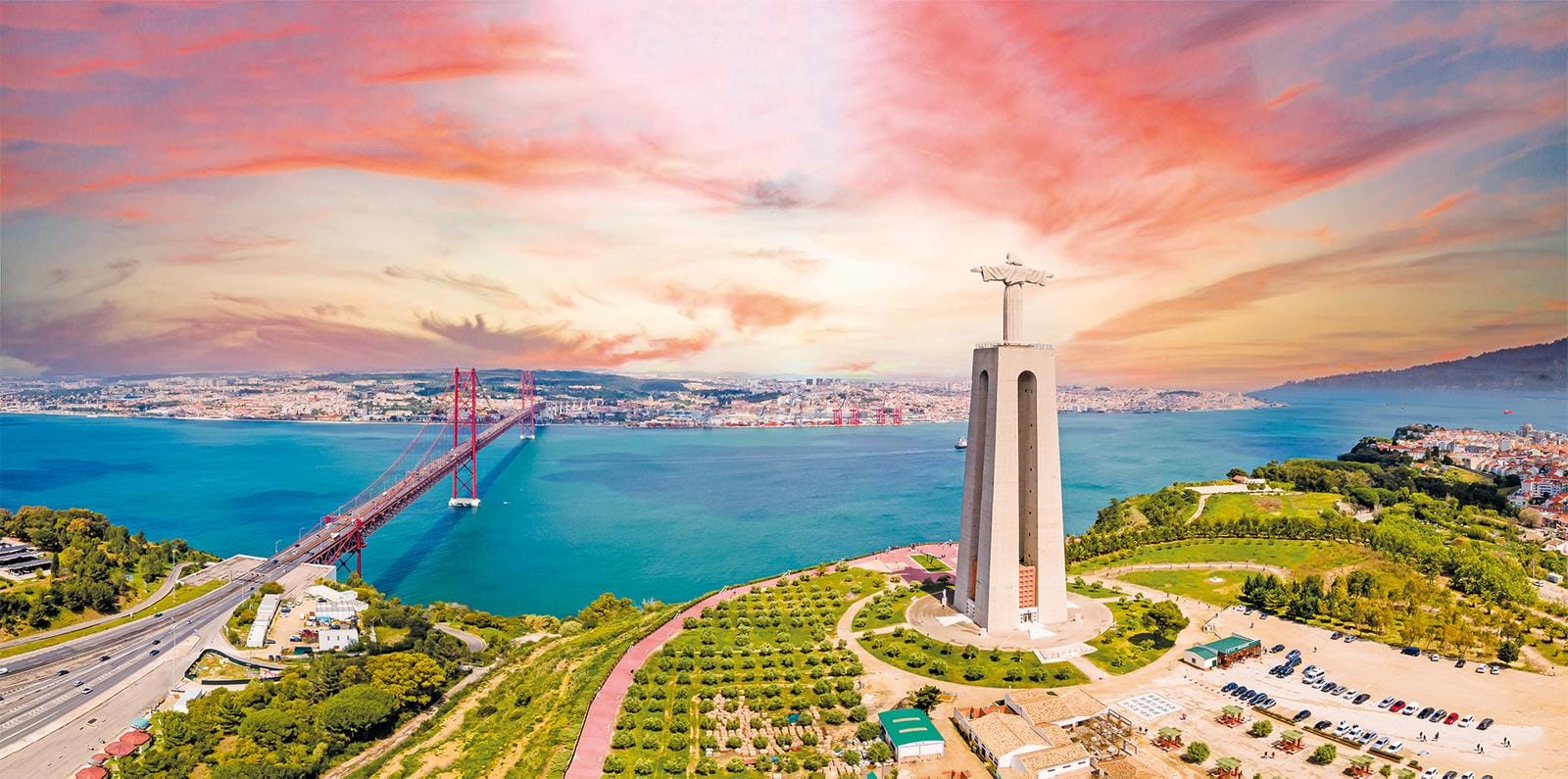 Lissabon, Portugal: Christusstatue mit roter Brücke bei dramatischem Sonnenuntergang.