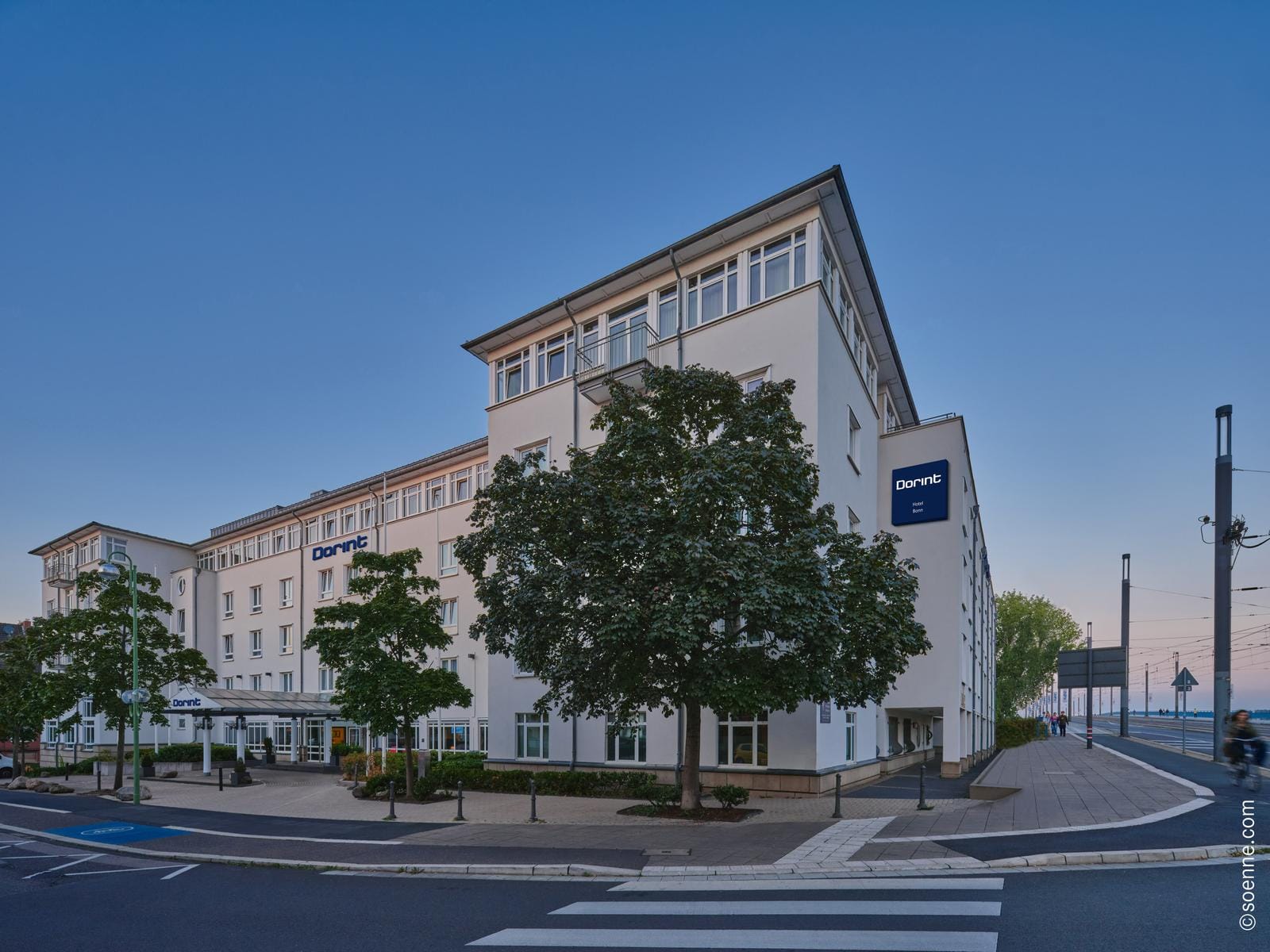 Modernes Stadt-Hotel mit heller Fassade, an einer Straßenecke gelegen.