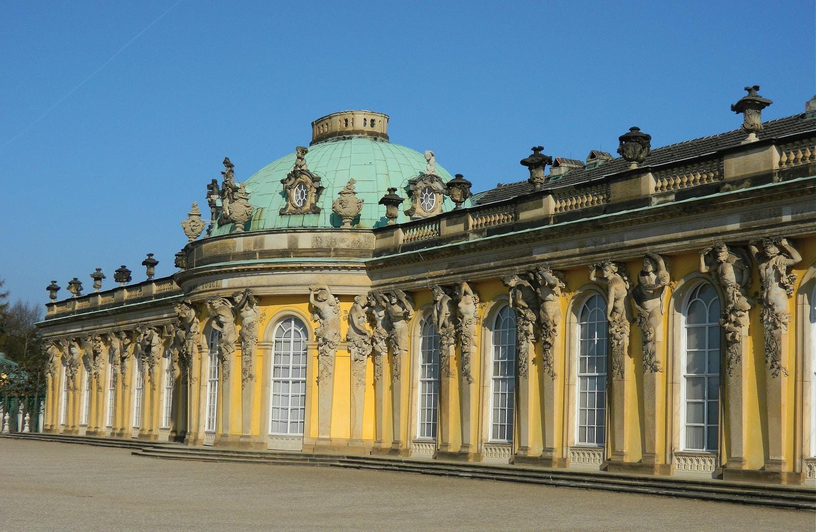 Barocke Fassaden von Schloss Sanssouci in Potsdam, Gelb mit grüner Kuppel.