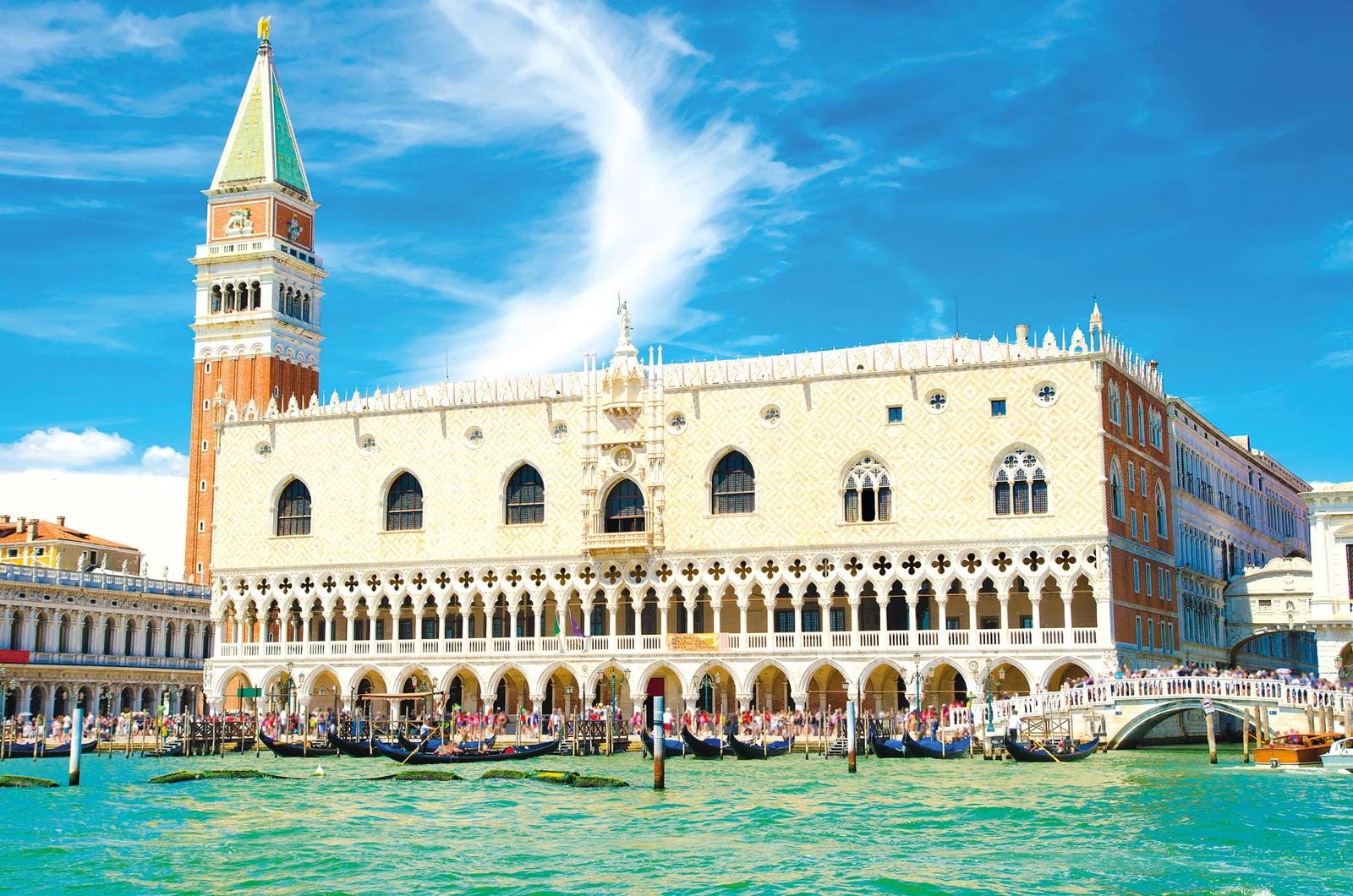 Dogenpalast in Venedig, Italien, vor blauem Himmel, Gondeln auf dem Kanal.