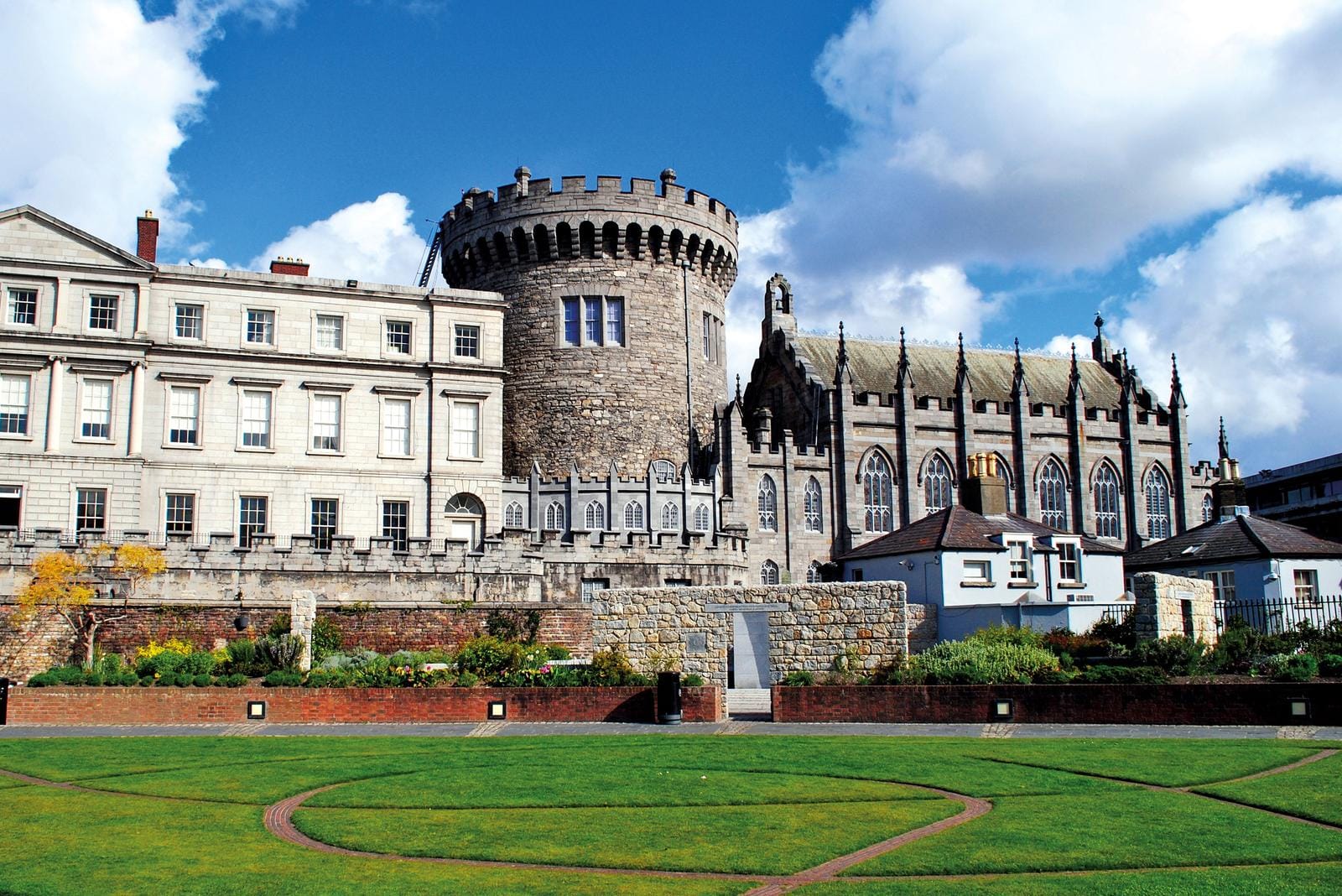 Historische Burg in Dublin, Irland vor blauem Himmel mit gepflegtem Rasen.