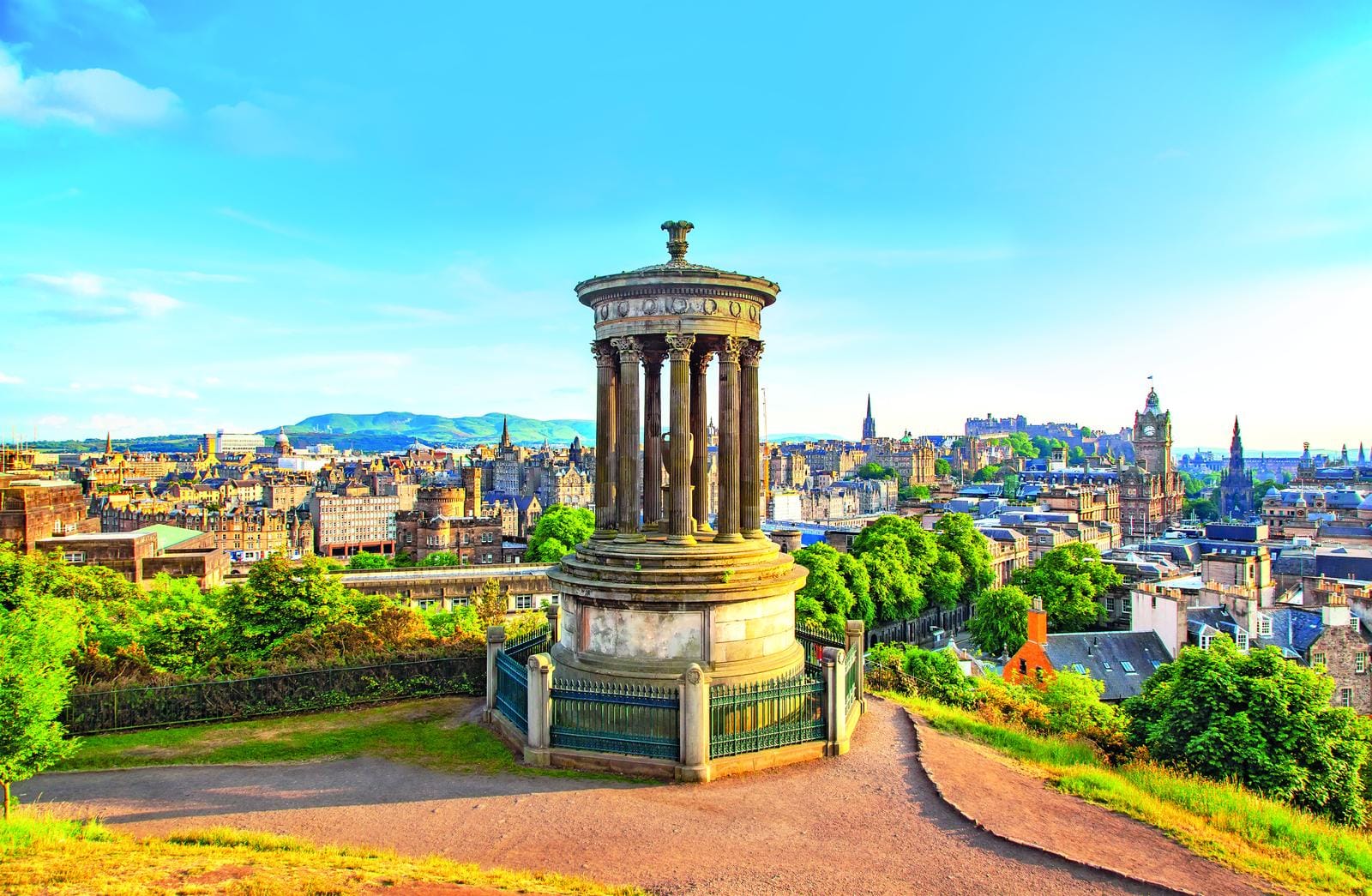 Calton Hill, Edinburghs Skyline mit Nelson Monument und grünem Stadtblick bei klarer Sonne.