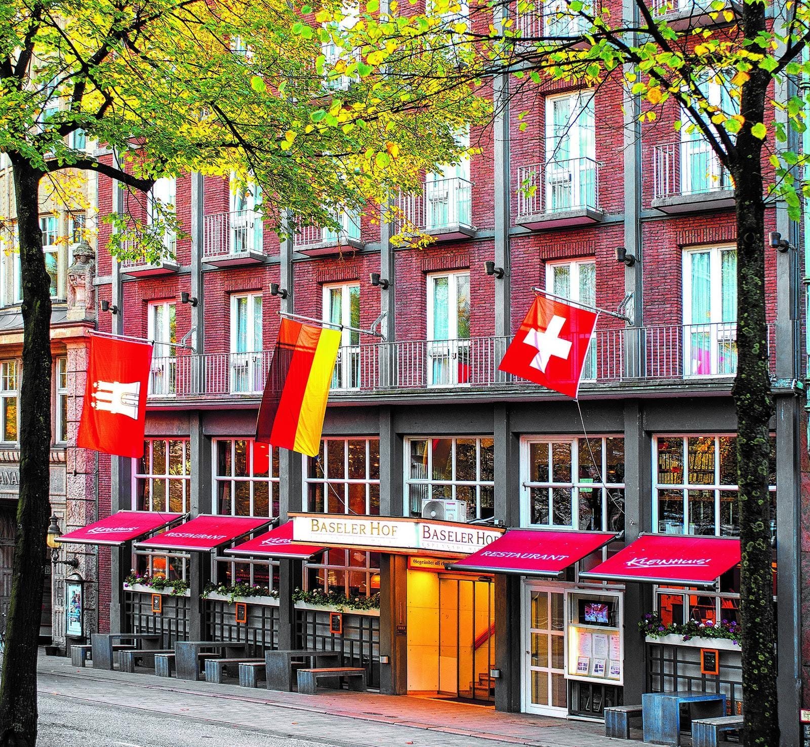 Backstein-Hotel in Hamburg, Deutschland mit Flaggen und roter Markise.