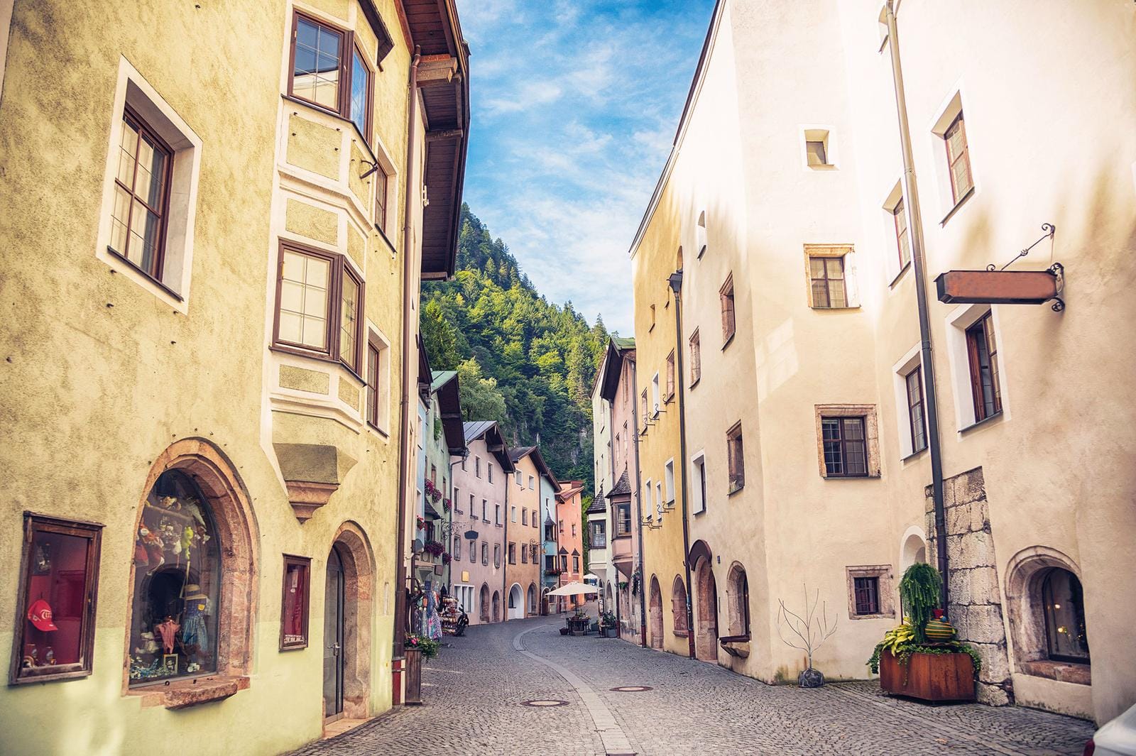 Malerische Altstadtgasse in Österreich mit bunten Fassaden und gepflasterten Wegen.