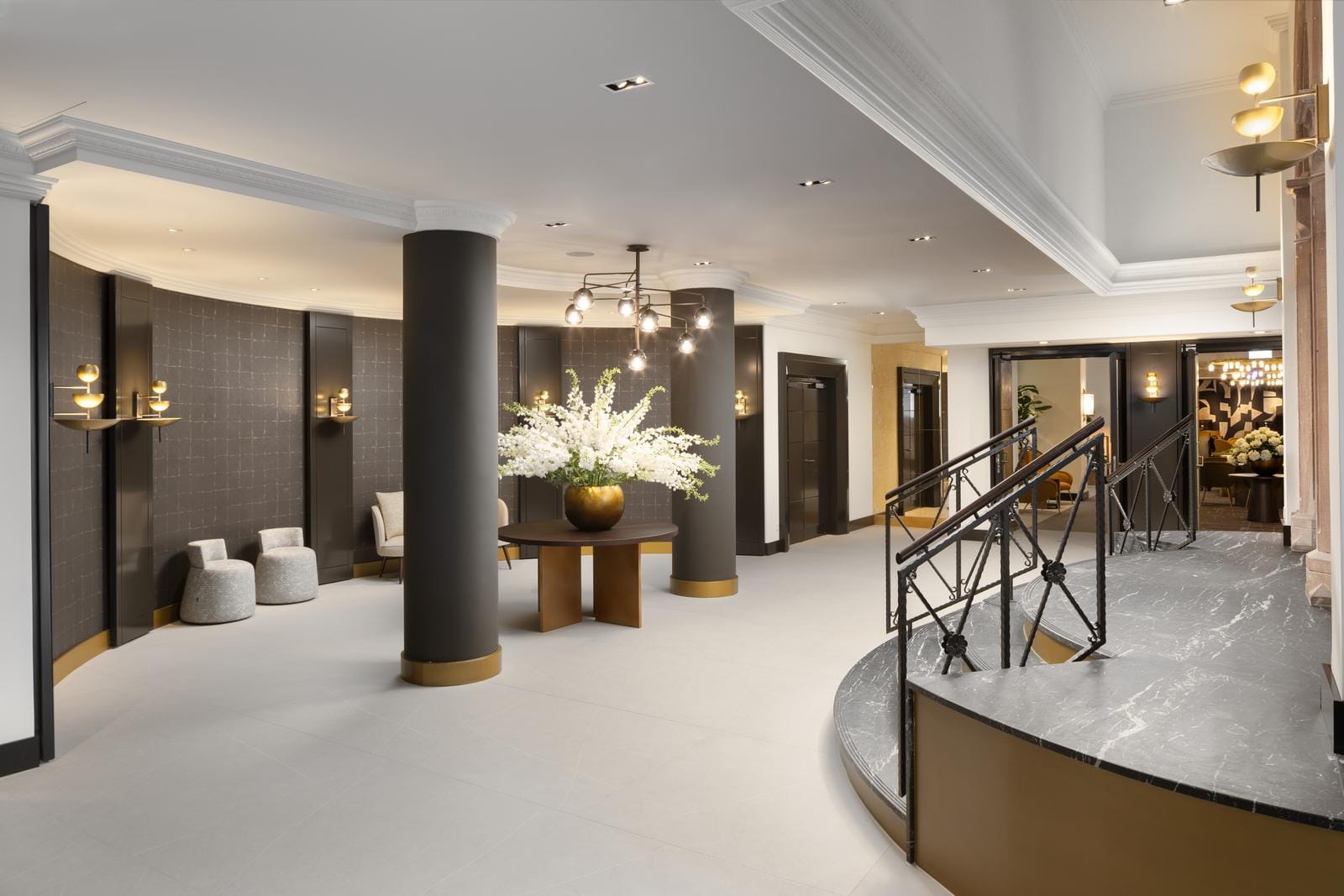 Elegante Hotellobby mit Marmorakzenten, modernen Sitzgelegenheiten und Blumenarrangement.