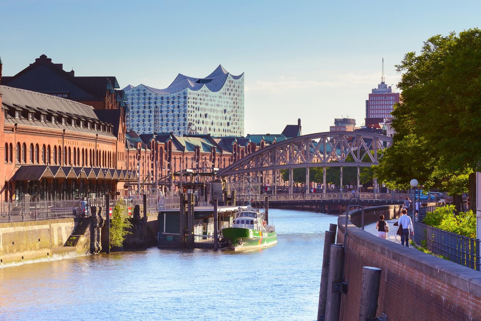 Hamburg, Deutschland; Elbphilharmonie und Speicherstadt im Sonnenlicht; Brücke und Kanal.