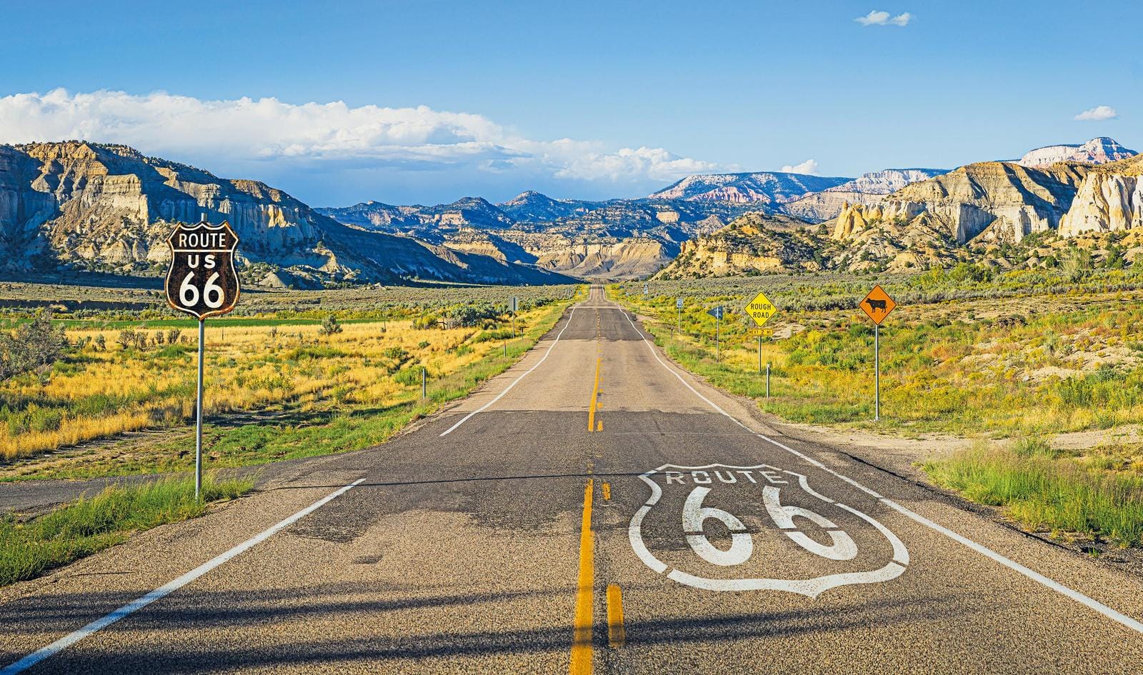Route 66 in Wüstenlandschaft mit Bergen und blauem Himmel, USA.