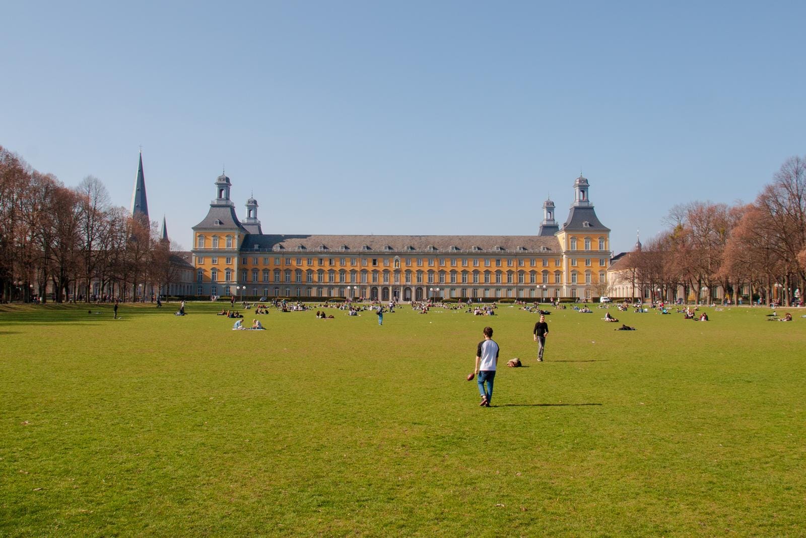 Grüne Wiese vor dem historischen Hauptgebäude der Universität Bonn, Deutschland.