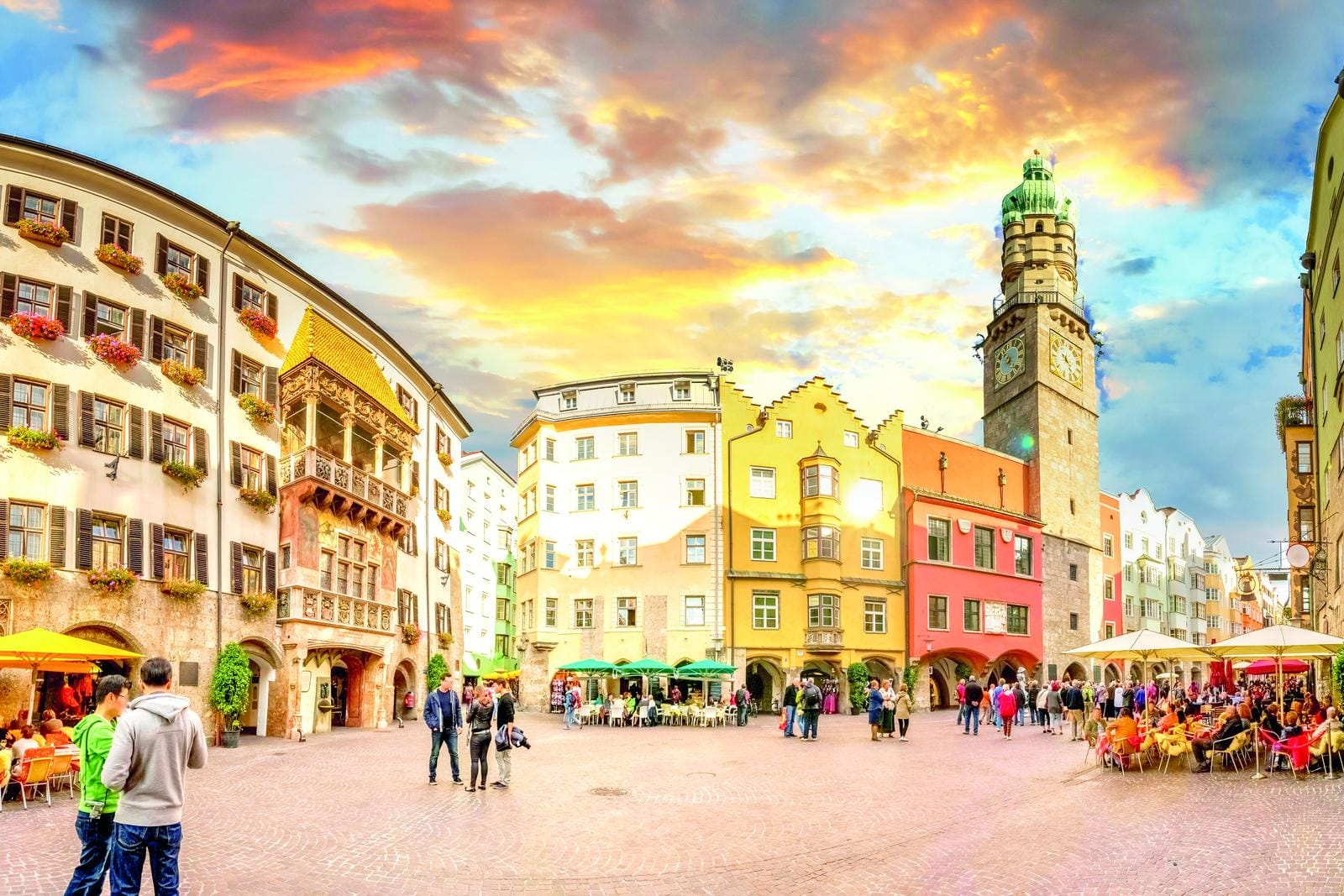Bunter Marktplatz in Innsbruck, Österreich, mit historischen Gebäuden und lebendigem Treiben.