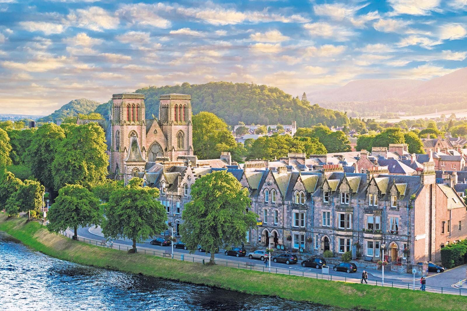 Inverness, Schottland: Kathedrale am Flussufer, umgeben von grünen Hügeln und historischer Architektur.