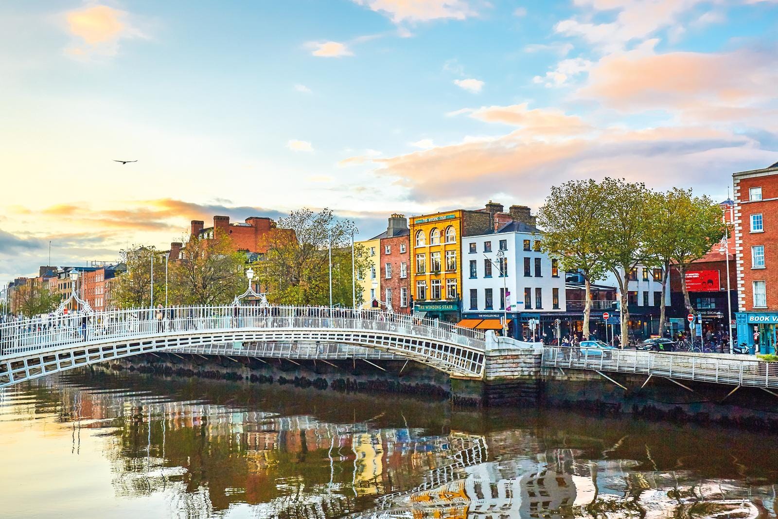 Dublin, Irland; Ha'penny Bridge über den Fluss Liffey, umgeben von bunten Fassaden.