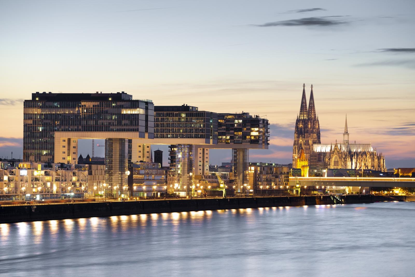 Köln, Rheinauhafen bei Abenddämmerung, moderner Kranhaus-Komplex und der Dom.