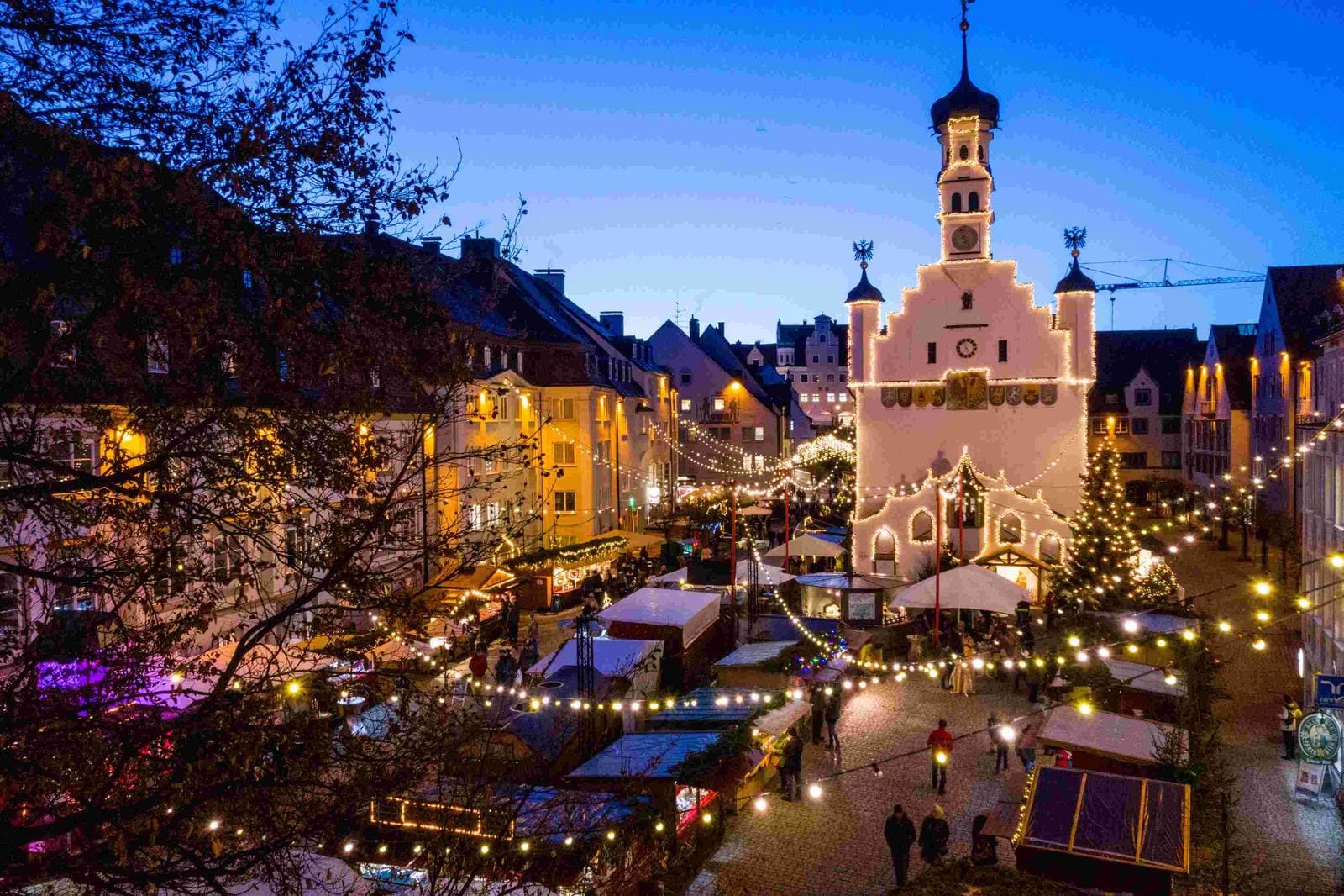 Weihnachtsmarkt in Ravensburg, Deutschland mit beleuchtetem historischen Rathaus.