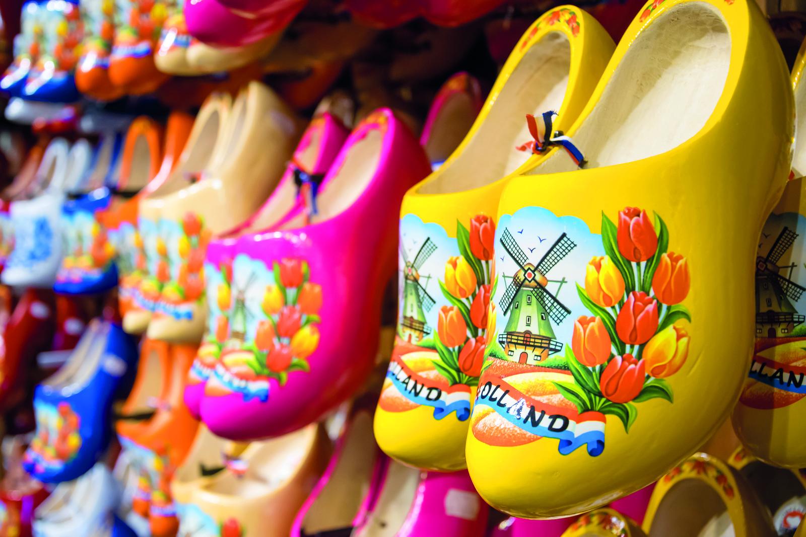 Bunte, holländische Holzschuhe mit Tulpen und Windmühlenmotiv, lebhaft und traditionell.