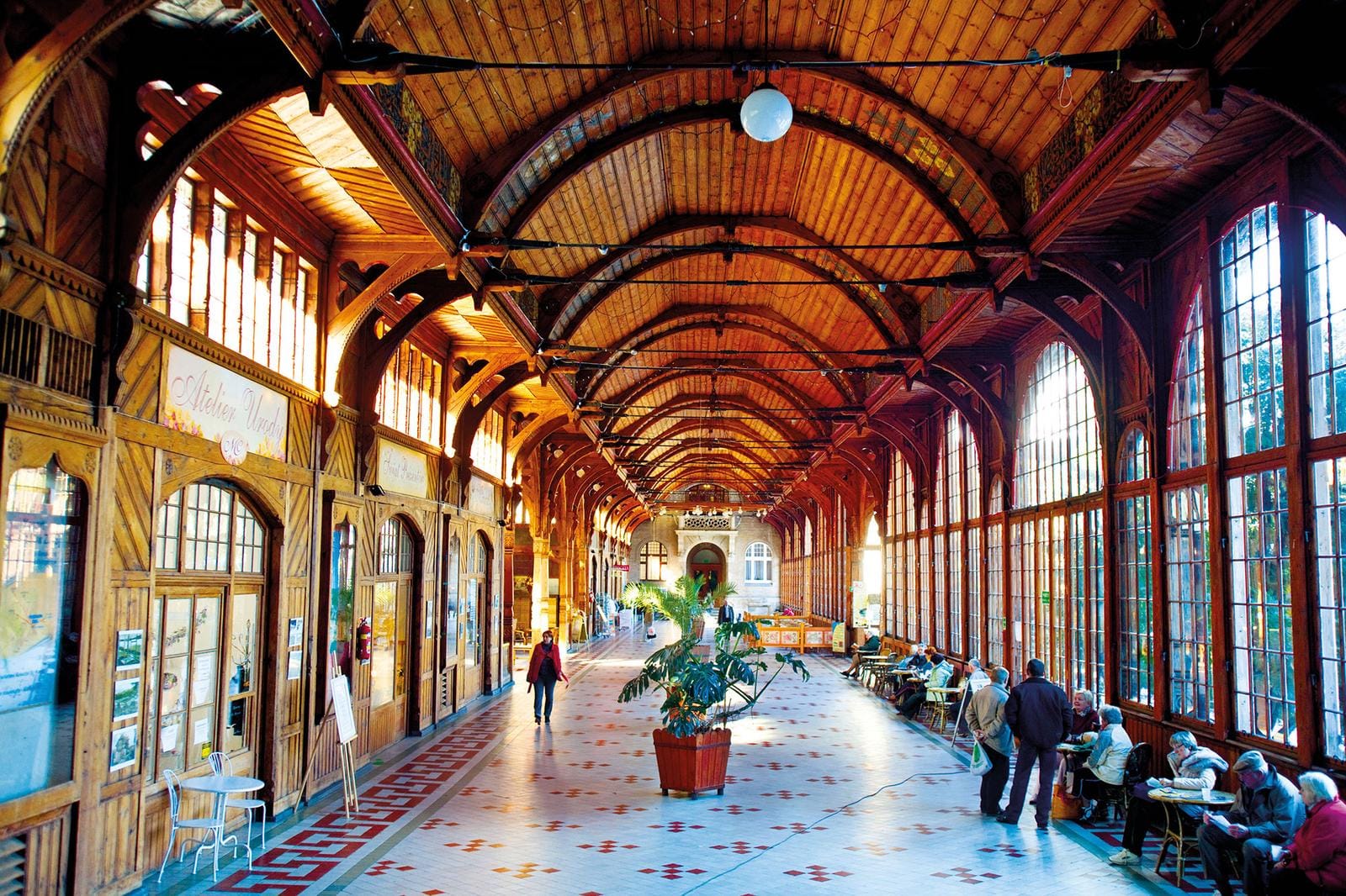 Holzverkleidete Kurhalle mit hohen Fenstern und geschwungenem Dach, einladend und gemĂĽtlich.