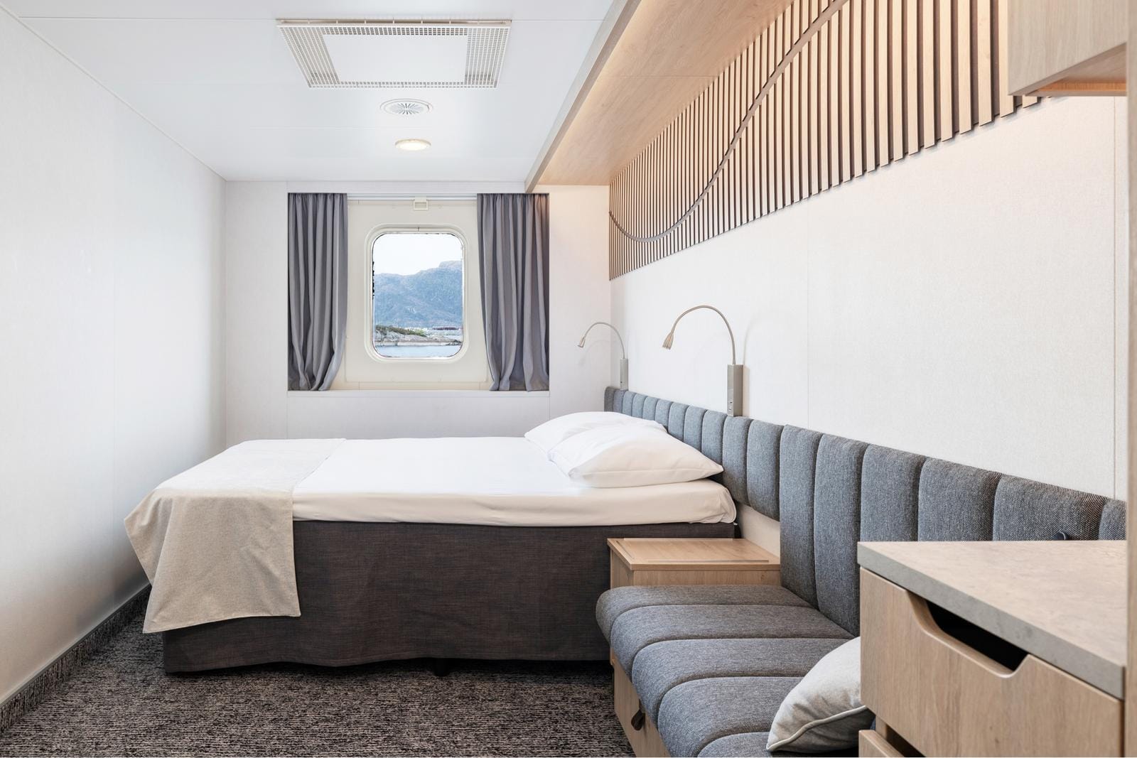 Helles Kabinenzimmer mit Bergblick, vielleicht auf einer Kreuzfahrt in Norwegen.