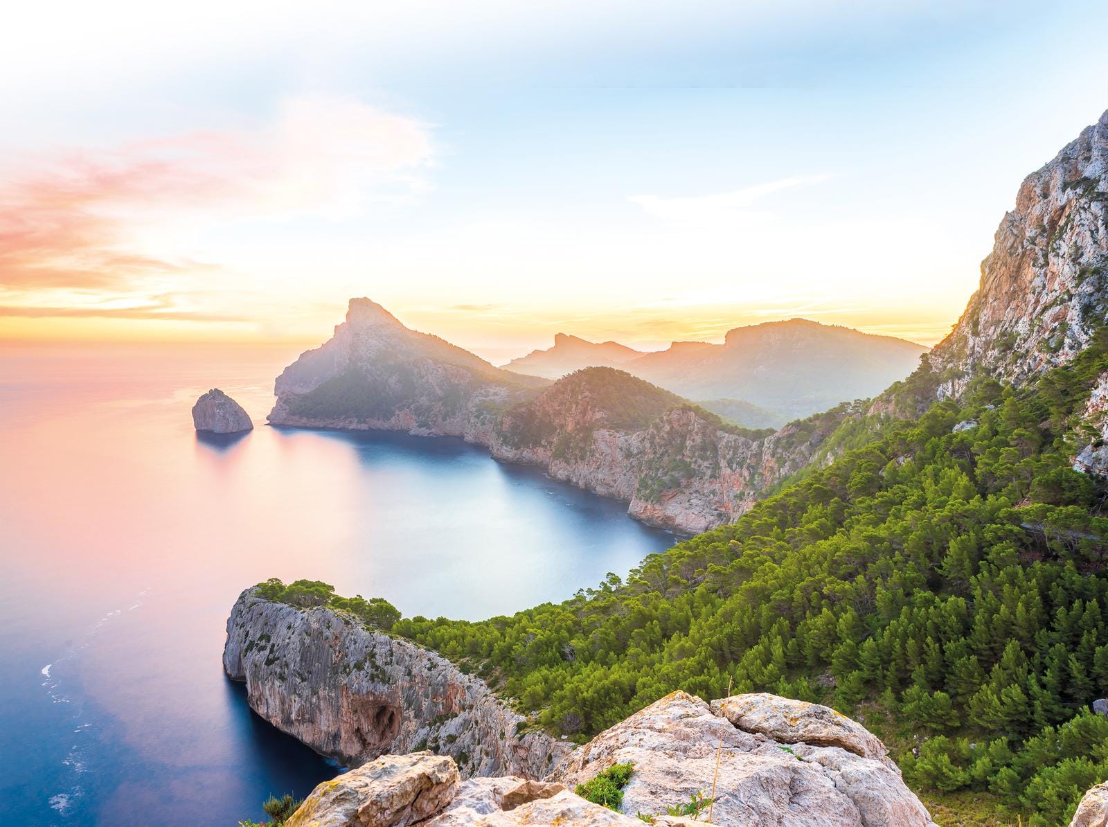 Malerische Küstenlandschaft auf Mallorca bei Sonnenuntergang, mit steilen Klippen und Meer.