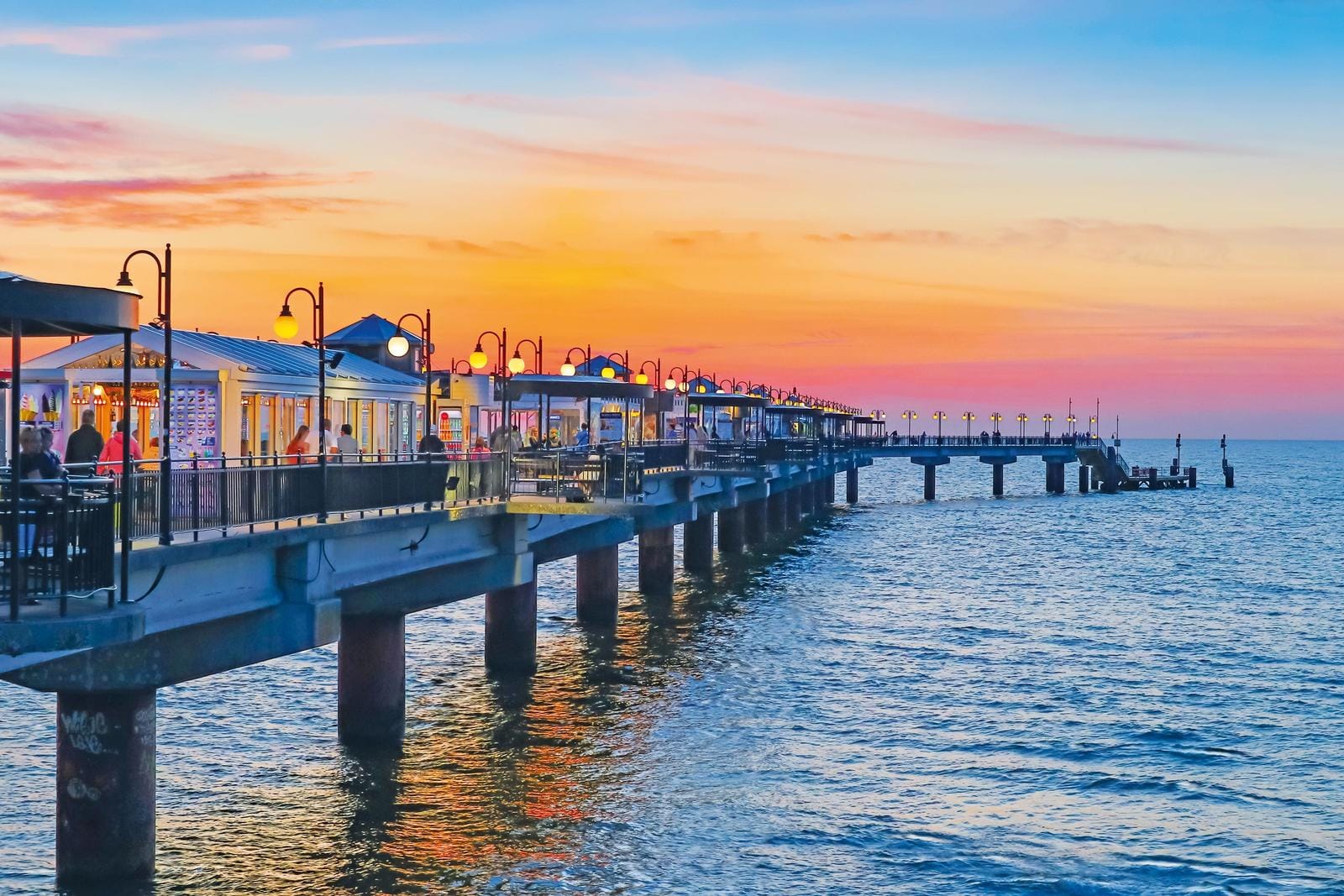 Seebrücke bei Sonnenuntergang in Sellin, Deutschland, mit romantischem Laternenschein.