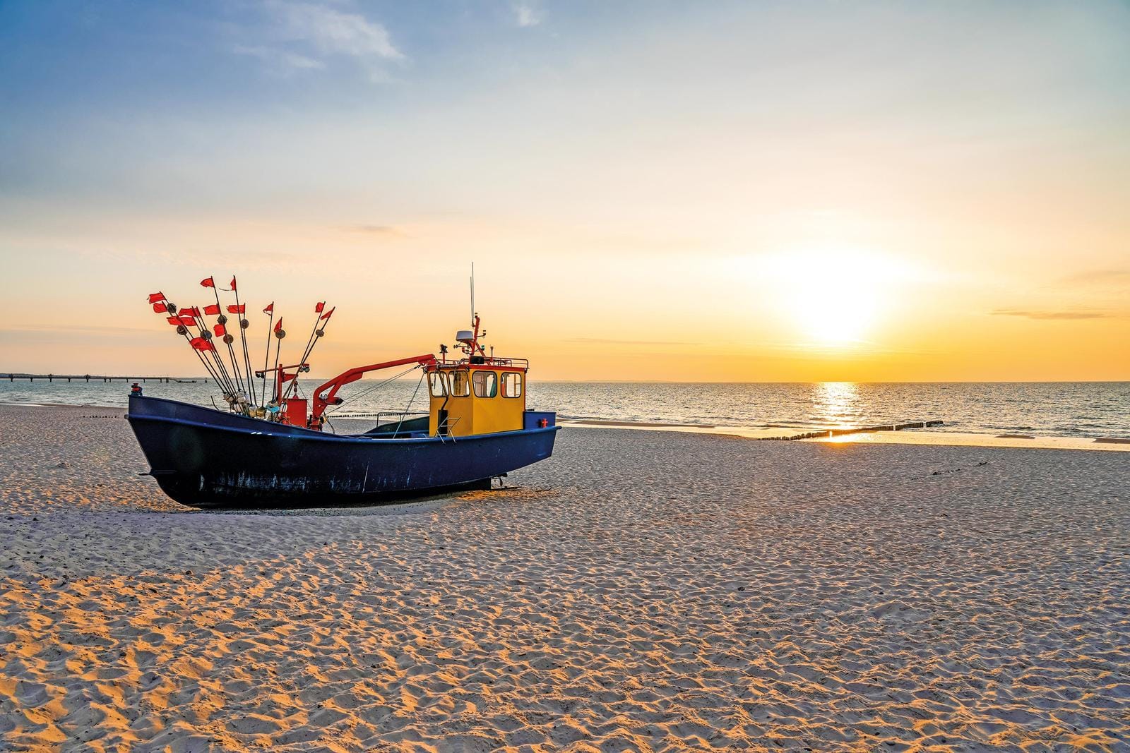 Fischerboot am Strand bei Sonnenuntergang, ruhige Ostsee, polnische Küste.