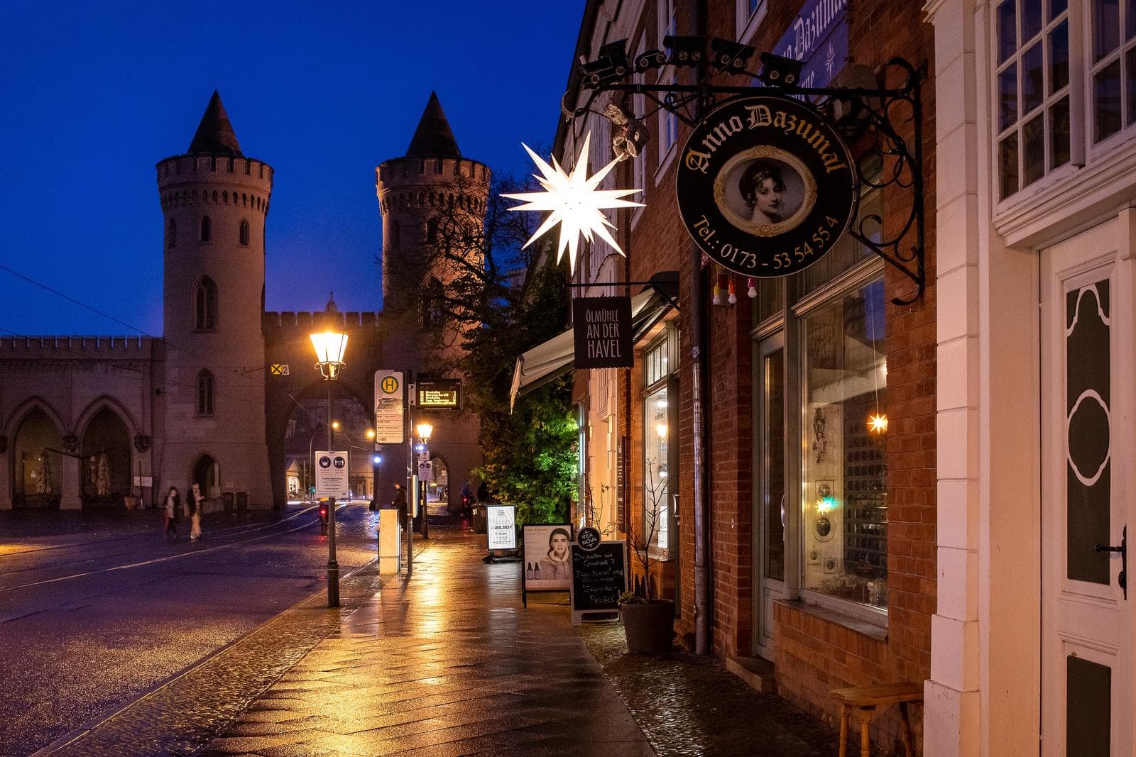 Potsdam, Deutschland; beleuchtete Nauener Tor bei Dämmerung, stimmungsvolle Gasse.