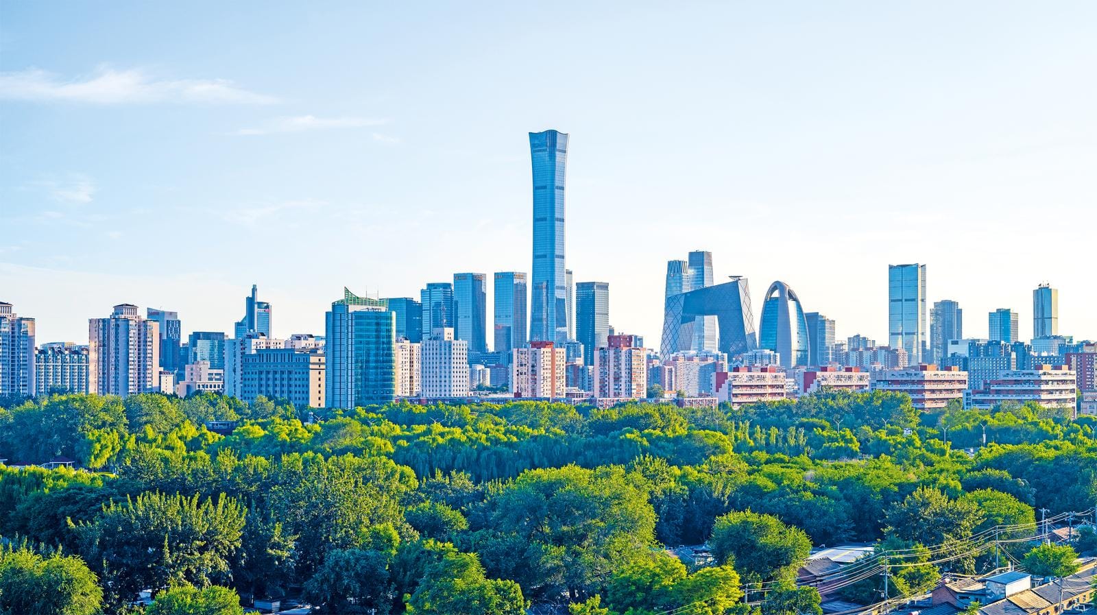 Skyline von Peking, China, mit modernen Wolkenkratzern und üppigem, grünem Park.