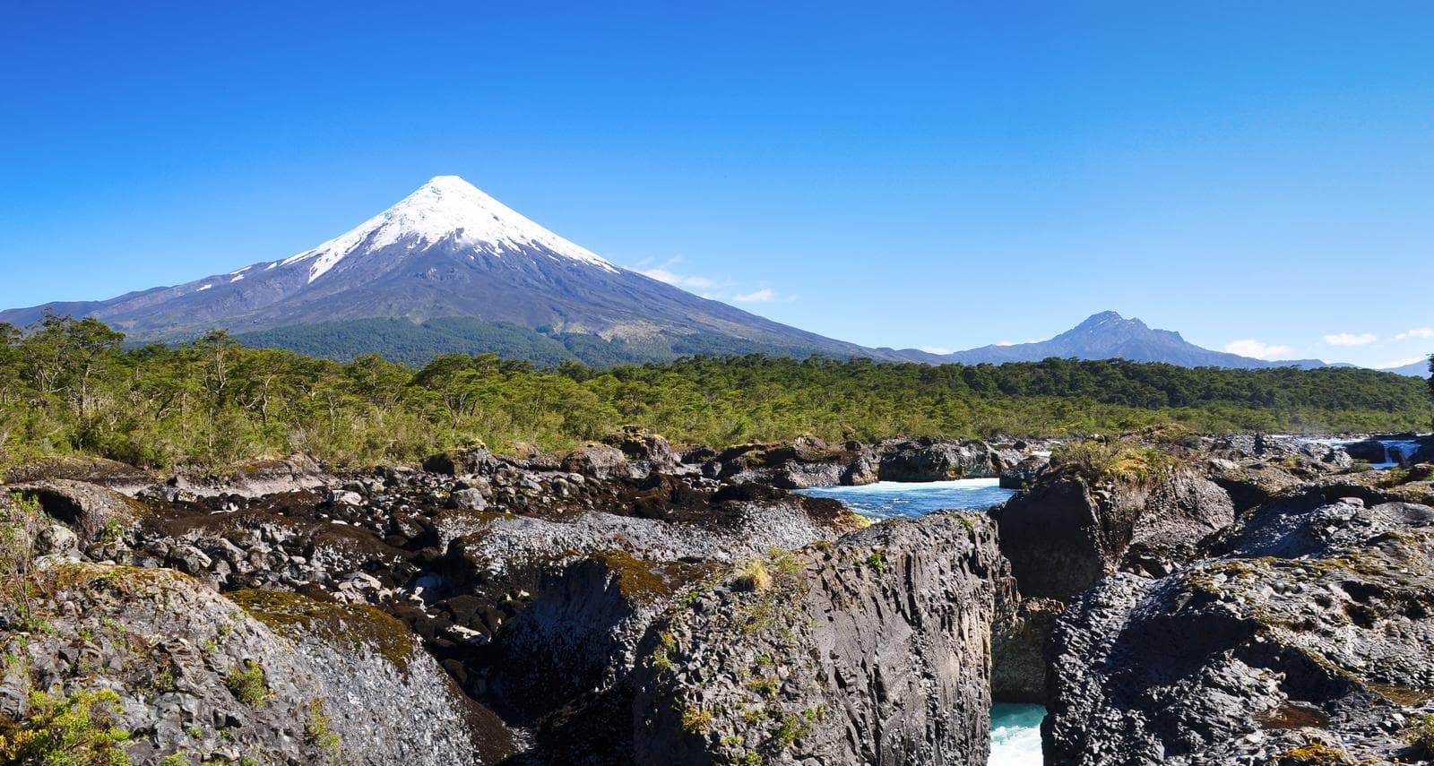 Schneebedeckter Vulkan Osorno in Chile, umgeben von grünen Wäldern und blauen Flüssen.