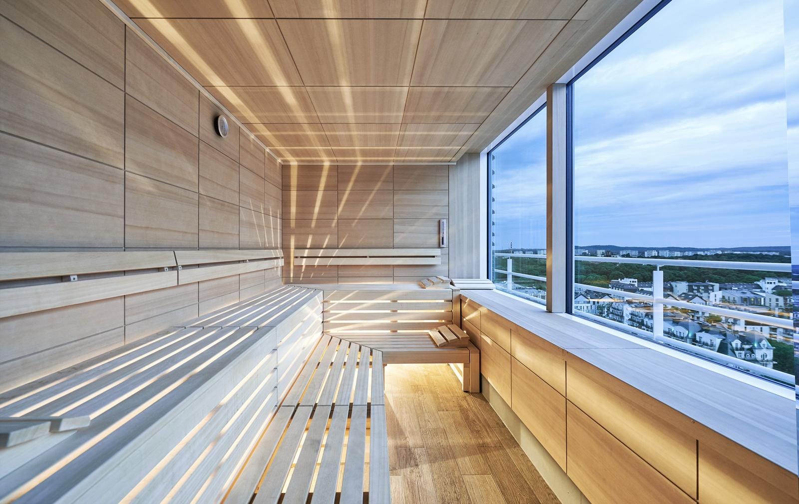 Moderne Sauna mit Holzverkleidung und Panoramafenster mit Stadtblick.
