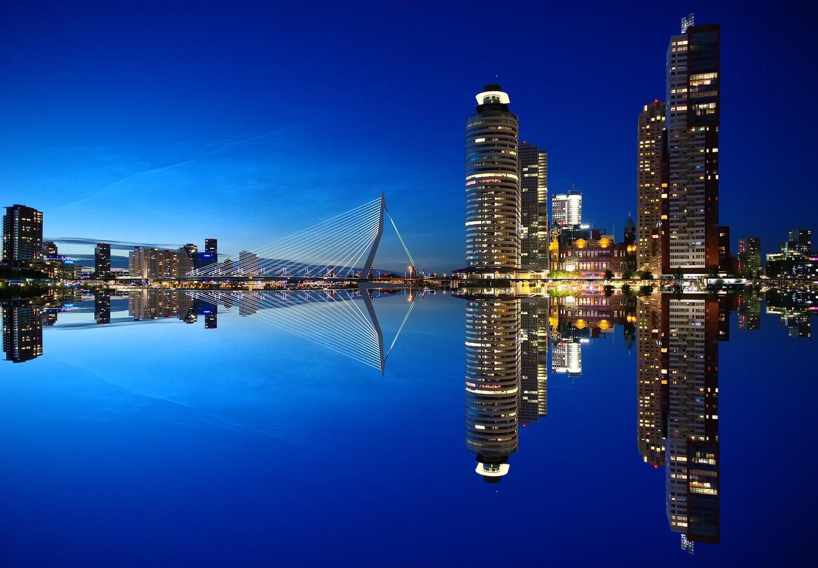 Moderne Skyline bei Nacht spiegelt sich im Wasser, beeindruckend in Rotterdam, Niederlande.