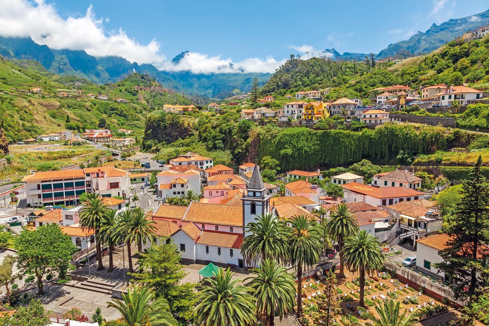 Bergort auf Madeira, Portugal, mit roten Dächern und grünen Hügeln.