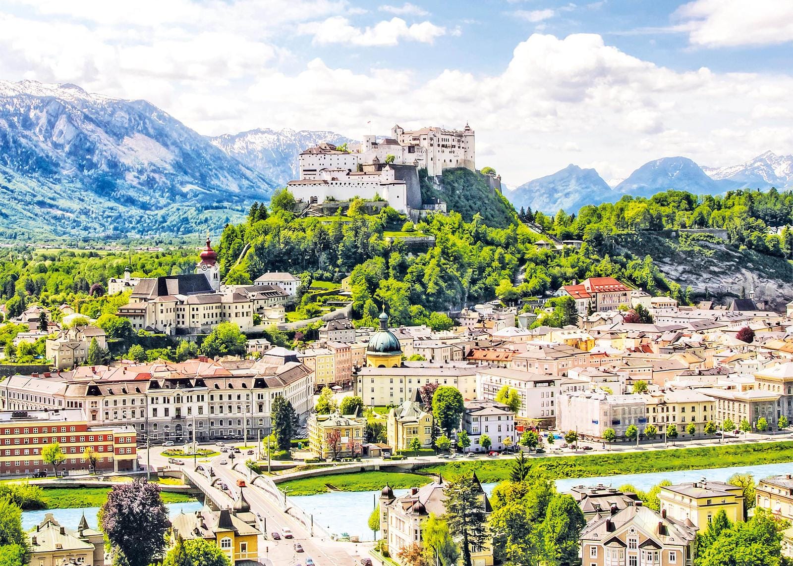 Historische Festung auf einem grünen Hügel über Salzburg, umgeben von atemberaubenden Alpen.
