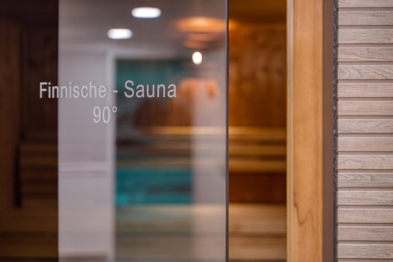 Moderne finnische Sauna mit Holzwänden, warmes Ambiente bei 90 Grad.