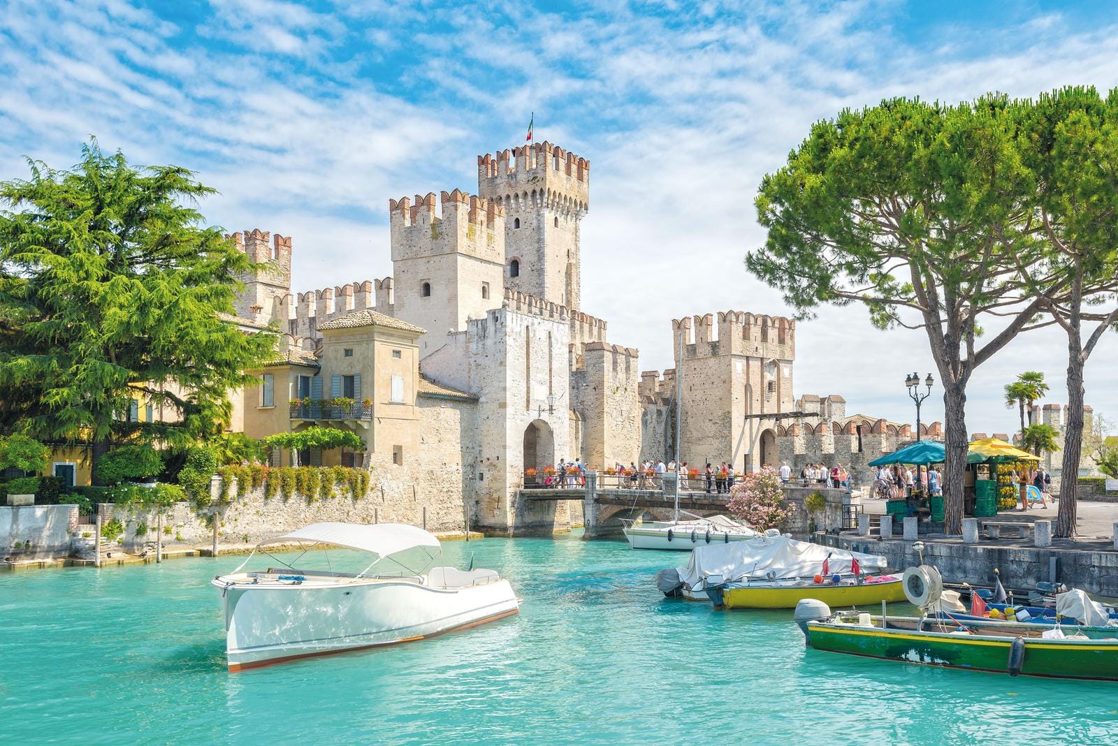 Idyllische Szene in Sirmione, Italien: Boote vor der mittelalterlichen Burg Scaliger.