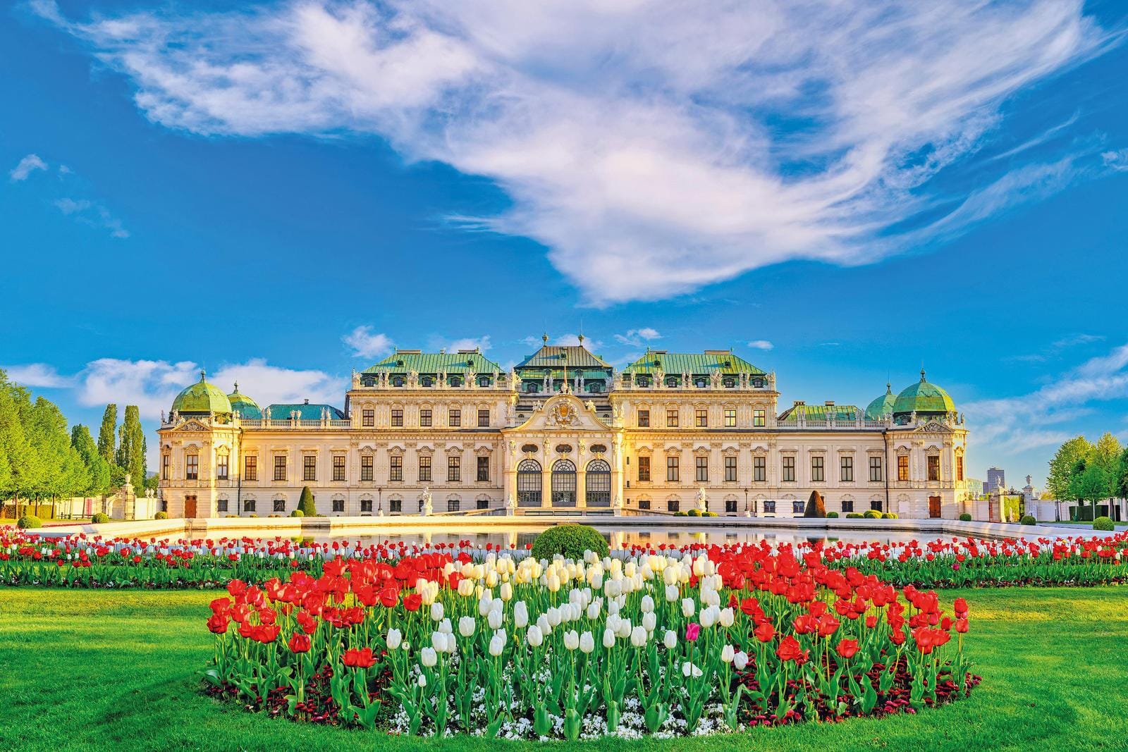 Prächtiges Schloss mit bunten Blumenbeeten, Wien, Österreich. Perfekt für einen sonnigen Tag.